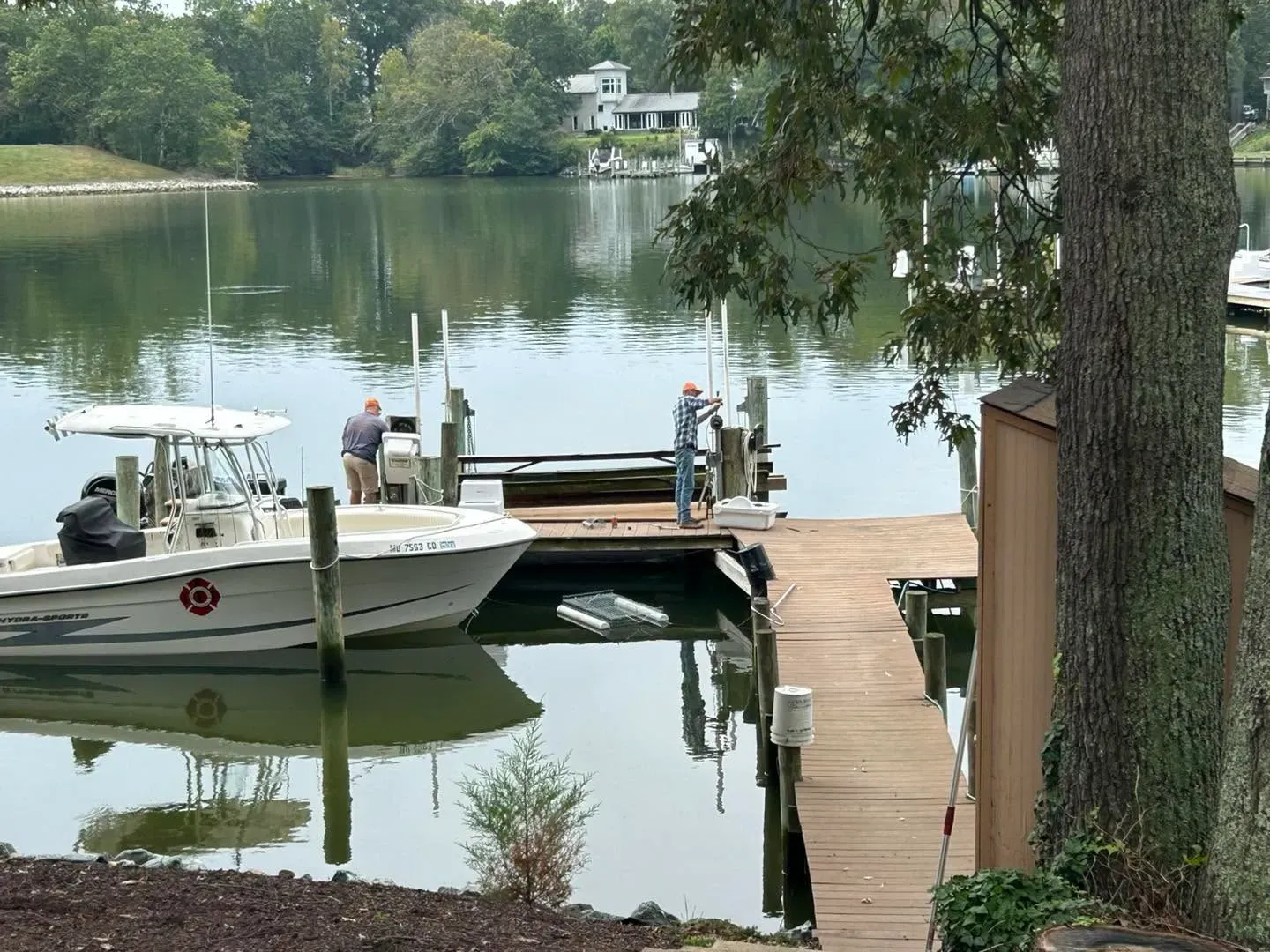 Boat beside a lift on a tree-lined creek