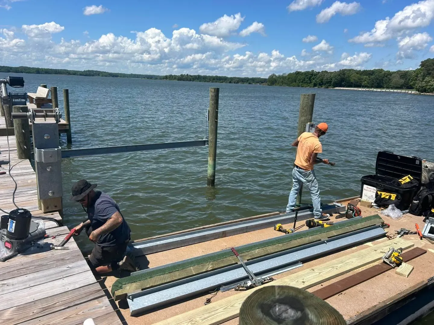 REBLS crew installing a pontoon lift cradle on a sunny Southern Maryland pier